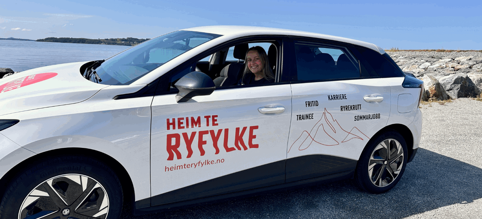 Foto: Andrea Hebnes Tobekk sitter i ny hvit bil med logoen til Heim te Ryfylke, med Ryfylke i bakgrunnen.