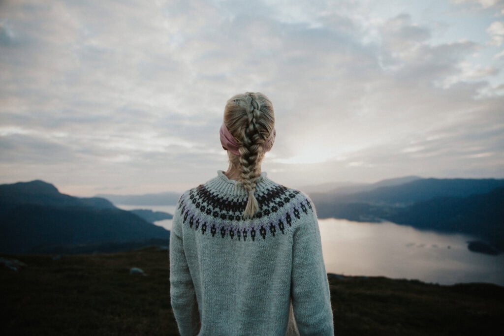 Person på fjelltur ser ut over fjorden