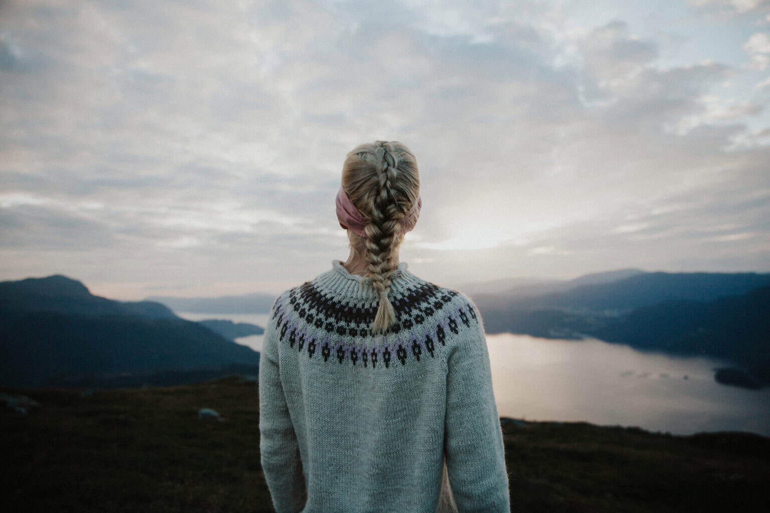 Person på fjelltur ser ut over fjorden